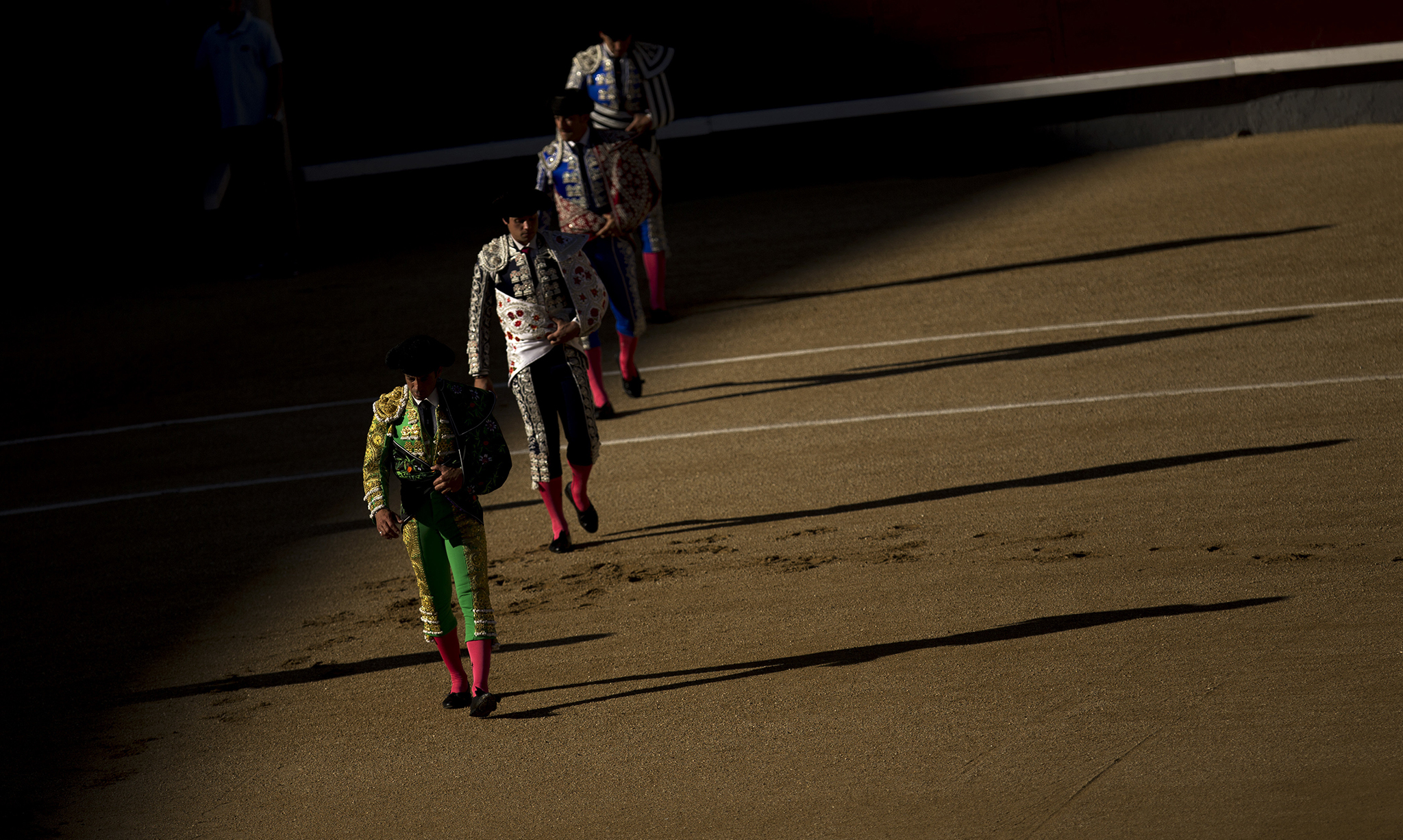 Bullfighters and assistants walk along the ring during the "paseillo" or ritual entrance to the arena prior a bullfight at the Las Ventas bullring in Madrid, Sunday, Aug. 7, 2016. (AP Photo/Francisco Seco)